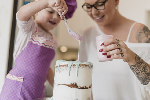 Mutter und Tochter dekorieren Kuchen - CAIF23062