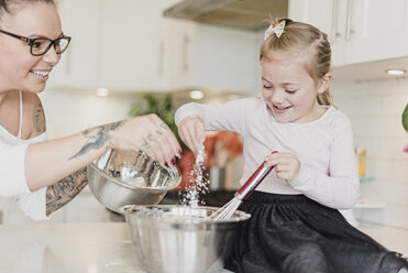 Mother and daughter baking in kitchen - CAIF23063