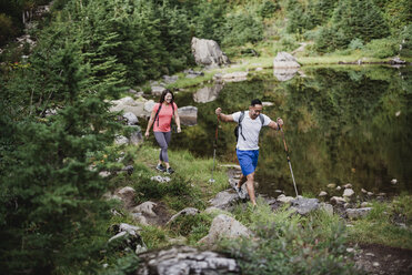 Ehepaar wandert entlang eines Sees im Wald - CAIF23071