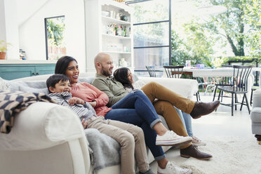 Familie beim Fernsehen auf dem Wohnzimmersofa - CAIF23111