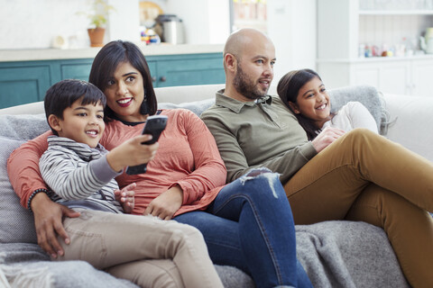 Familie beim Fernsehen auf dem Wohnzimmersofa, lizenzfreies Stockfoto