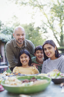 Porträt einer glücklichen Familie am Esstisch - CAIF23125