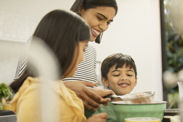 Mother and children baking in kitchen - CAIF23129