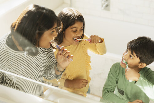 Mutter und Kinder beim Zähneputzen im Badezimmer - CAIF23131