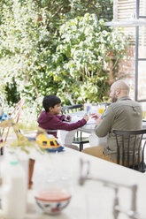 Vater und Sohn beim Malen am Tisch - CAIF23135