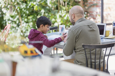 Vater und Sohn beim Malen am Tisch - CAIF23141