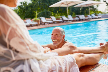 Glückliches Paar entspannt sich am sonnigen Schwimmbad des Resorts - CAIF23181