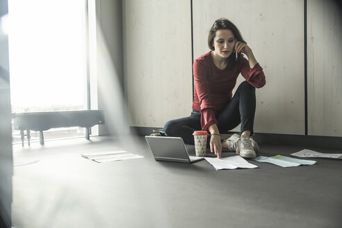 Geschäftsfrau bei der Arbeit auf dem Boden im Büro - UUF17077