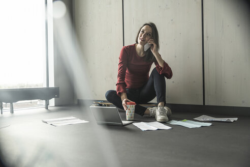 Geschäftsfrau bei der Arbeit auf dem Boden im Büro - UUF17078