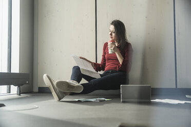 Businesswoman at work on the floor in office - UUF17080