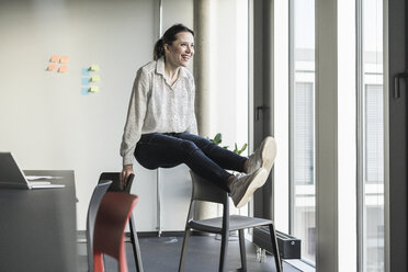 Glückliche Geschäftsfrau beim Sport im Büro - UUF17118