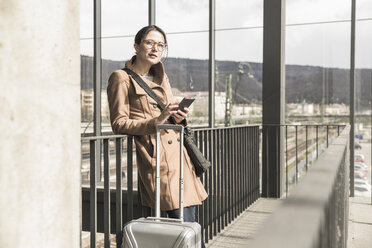Portrait of businesswoman with baggage and cell phone - UUF17135