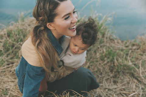 Mother holding her little daughter affectionately in nature stock photo