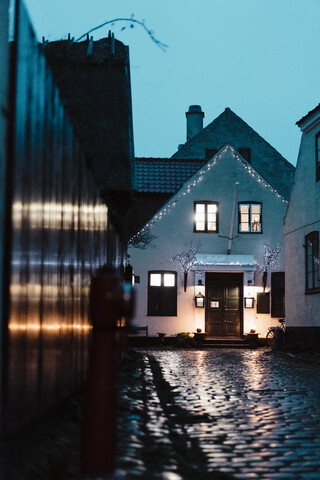 Dänemark, Dragor, beleuchtetes Haus in der Altstadt in der Dämmerung, lizenzfreies Stockfoto