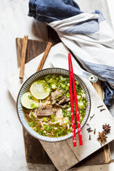 Bowl of Vietnamese Pho with rice noodles, mung beans, cilantro, spring onions and limes - SBDF03937