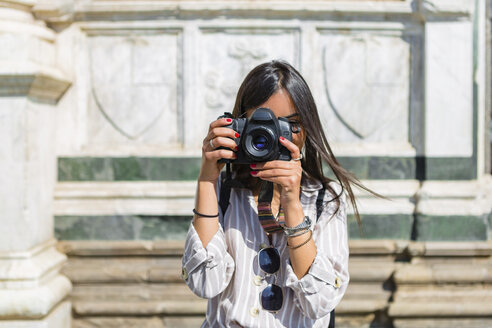 Italien, Florenz, junger Tourist beim Fotografieren mit Kamera - MGIF00330