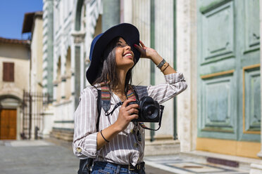 Italien, Florenz, glücklicher junger Tourist mit Kamera, der nach oben schaut - MGIF00336