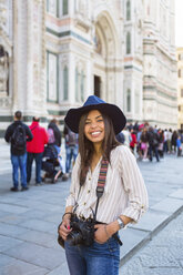 Italien, Florenz, Piazza del Duomo, Porträt eines glücklichen jungen Touristen mit Kamera - MGIF00352