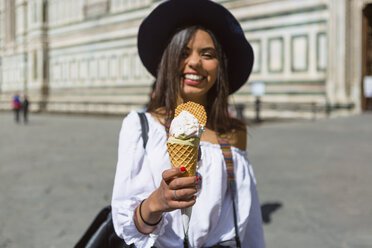 Italien, Florenz, Piazza del Duomo, glücklicher junger Tourist mit Eiswaffel - MGIF00360