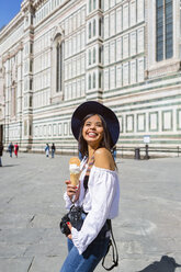 Italien, Florenz, Piazza del Duomo, glücklicher junger Tourist mit Kamera und Eiswaffel - MGIF00362
