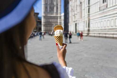 Italien, Florenz, Piazza del Duomo, Rückenansicht einer jungen Touristin mit Eiswaffel - MGIF00364