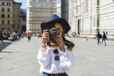 Italien, Florenz, Piazza del Duomo, junger Tourist beim Fotografieren mit Kamera - MGIF00366