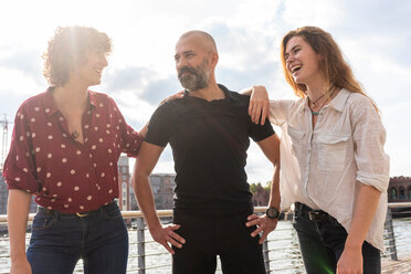 Man and female friends smiling on bridge - CUF49960