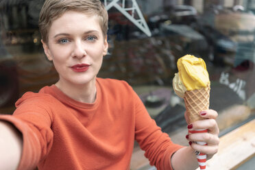 Woman taking selfie with ice cream in front of shop - CUF49992