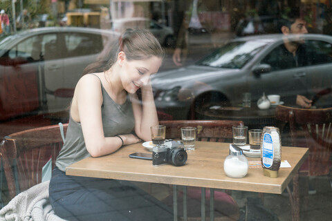 Junge Frau benutzt Smartphone in einem Cafe, lizenzfreies Stockfoto