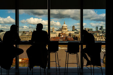 Silhouette von Menschen, die sich vor einem Glasfenster unterhalten, St. Paul's Cathedral im Hintergrund, City of London, UK - CUF50027