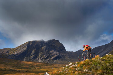 Männlicher Mountainbiker auf dem Fahrrad in einer Berglandschaft, Achnasheen, Schottische Highlands, Schottland - CUF50084