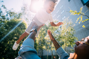 Father throwing son up in air in park - CUF50112