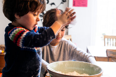 Boys playing with flour in mixing bowl - CUF50117