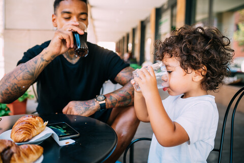Vater und Sohn trinken im Cafe, lizenzfreies Stockfoto