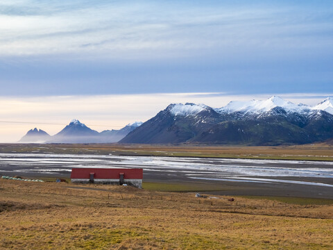 Island, Austurland, Landschaft mit Haus und Bergen auf dem Weg nach Egilsstadir, lizenzfreies Stockfoto