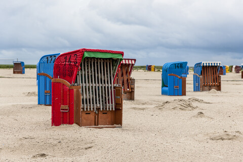 Deutschland, Nessmersiel, Strandkörbe mit Kapuze am Sandstrand, lizenzfreies Stockfoto