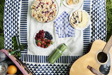 Draufsicht auf gesunde Picknick-Snacks auf einer Decke - IGGF00980