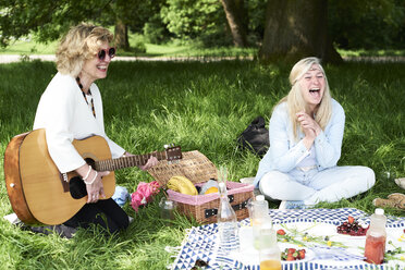 Frauen mit Gitarre haben Spaß bei einem Picknick im Park - IGGF00999