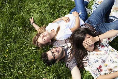 Top view of happy friends lying in a meadow in park stock photo