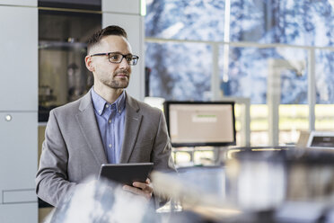 Portrait of businessman with tablet in a modern factory - DIGF06527