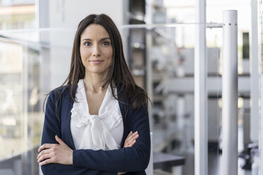 Portrait of smiling businesswoman in a modern factory - DIGF06548