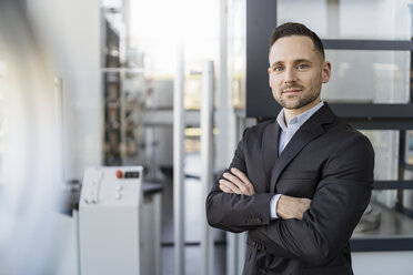 Portrait of confident businessman in a modern factory - DIGF06593