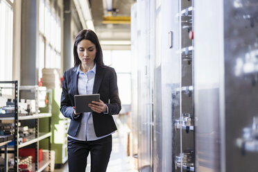 Businesswoman using tablet in a modern factory - DIGF06631