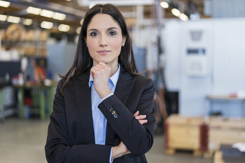 Porträt einer selbstbewussten Geschäftsfrau in einer Fabrik, lizenzfreies Stockfoto