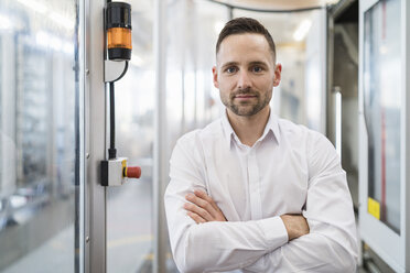 Portrait of confident businessman in a modern factory - DIGF06669