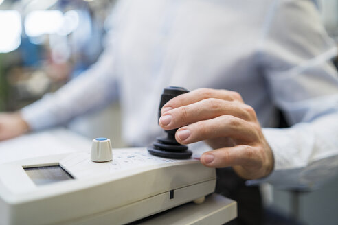 Close-up of man operating machine with control in a factory - DIGF06690