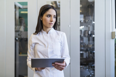 Woman with tablet wearing lab coat in modern factory - DIGF06705