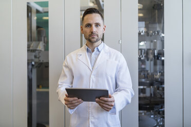 Porträt eines Mannes mit Tablet und Laborkittel in einer modernen Fabrik - DIGF06707