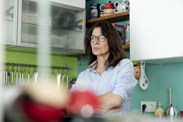 Porträt einer nachdenklichen reifen Frau in der Küche zu Hause - FLLF00090