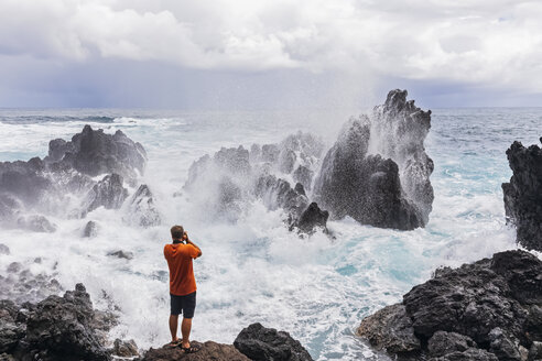 USA, Hawaii, Big Island, Laupahoehoe Beach Park, Mann fotografiert die brechende Brandung an der felsigen Küste - FOF10569